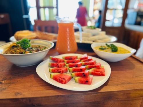 a plate of fruit on a table with bowls of food at Cabin 7000 feet Nuwaraeliya in Nuwara Eliya