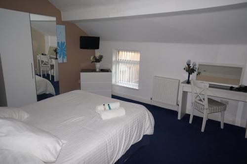 1 dormitorio con cama, escritorio y espejo en South Beach Apartments en Blackpool