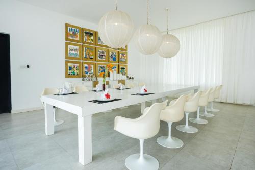 a white dining room with a white table and chairs at Green Turtle Villa by The Serendipity Collection in Bentota