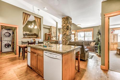a kitchen and living room with a sink and a dishwasher at Treetops Ski Luxury Townhouse in Big White