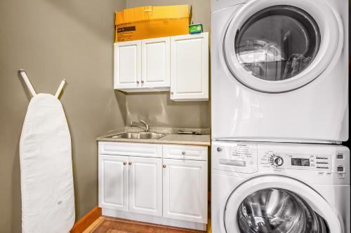 a kitchen with a washing machine and a sink at Treetops Ski Luxury Townhouse in Big White