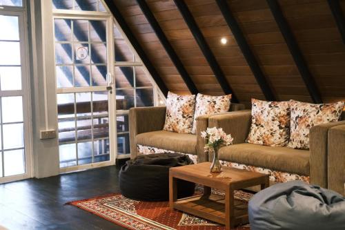 a living room with two couches and a table at Cabin 7000 feet Nuwaraeliya in Nuwara Eliya
