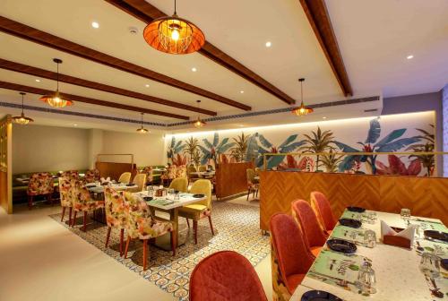 a restaurant with tables and chairs in a room at Park Residency Puthuppally in Putuppalli