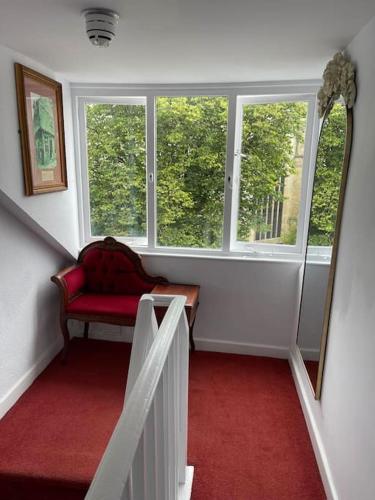 a stairway with a red couch in a room with windows at Abbey view in Selby