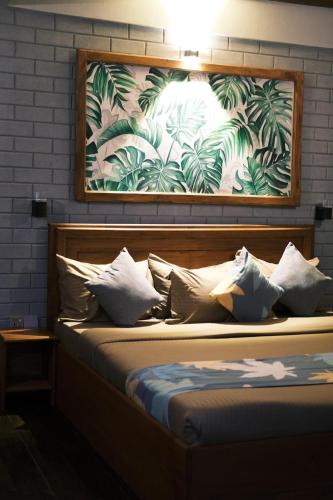 a bed with pillows and a painting on the wall at Cabin 7000 feet Nuwaraeliya in Nuwara Eliya