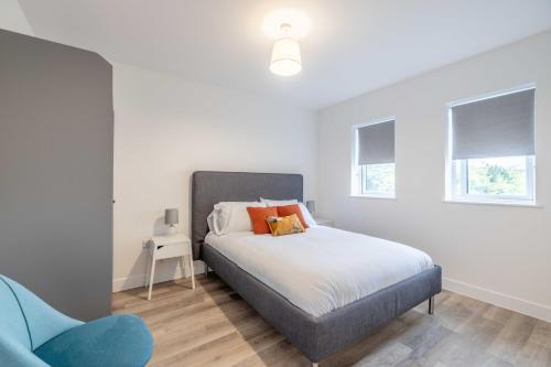 a bedroom with a bed and a blue chair at ENTR - Modern Apartments in Windsor in Windsor