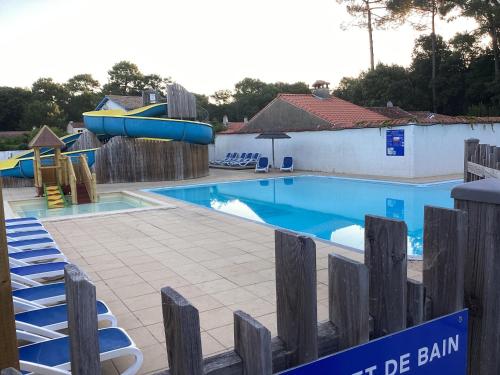 une piscine avec un toboggan et une aire de jeux dans l'établissement Mobile home 3 chambres Camping Flower Odalys, à Longeville-sur-Mer