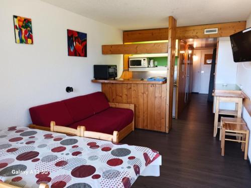 un salon avec un canapé rouge et une cuisine dans l'établissement Résidence Pierra Menta - Studio 5 personnes proche des pistes et des commerces dans le village du Charvet à Arc 1800 MAE-2197, à Arc 1800