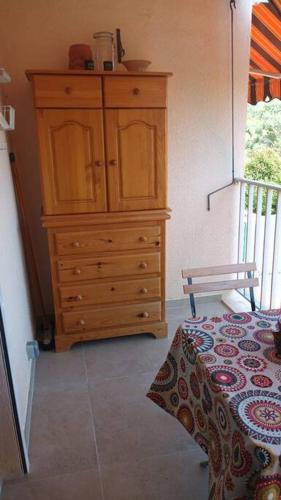- une commode en bois dans une chambre dans l'établissement Coquet studio vue mer et place privée 10mn mer, à Carqueiranne