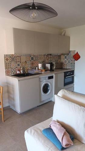 une cuisine avec un évier et une machine à laver dans l'établissement Coquet studio vue mer et place privée 10mn mer, à Carqueiranne