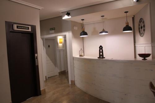 a bar in a room with pendant lights at Hotel Jakue in Puente la Reina