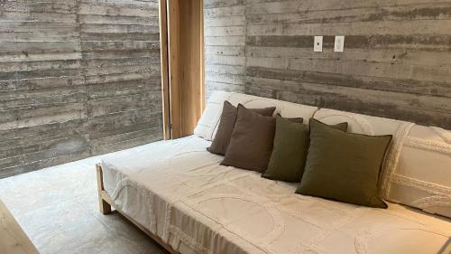 a bedroom with a white bed with green pillows at Sich - Casa Macu Saladita surf break in La Salada