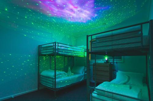 a bedroom with two bunk beds with a starry ceiling at Sauna, King Beds, Tranquility Base Fun Large Home in Saint Leonards