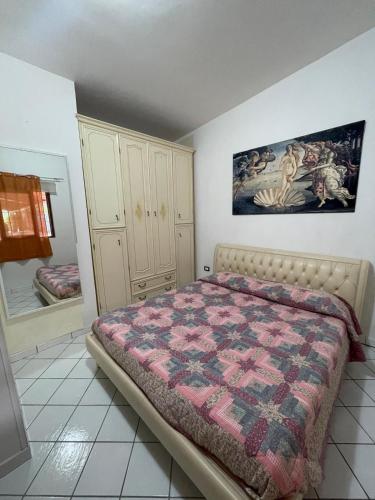 a bedroom with a bed with a quilt on it at Guest House Di Bartolomeo in Capaccio-Paestum