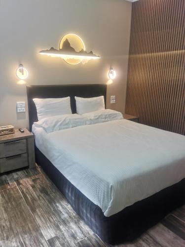 a bedroom with a large bed and a night stand at Bha in Perth