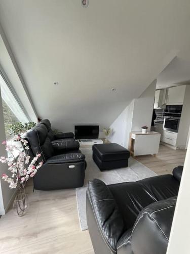 a living room with black leather furniture and a living room at Welcome to our new build house! in Landvetter