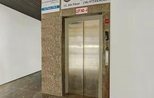 a elevator in a building with a sign on it at Hotel Welcome, VIP Road Vesu in Surat