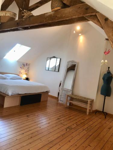 une chambre avec un lit et un miroir dans une pièce dans l'établissement Longère en Bretagne, à Nouvoitou