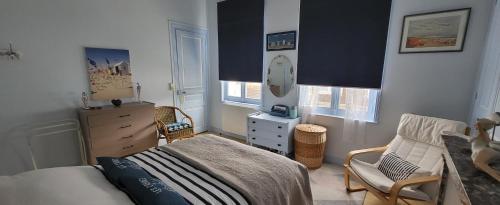 - une chambre avec un lit, une chaise et une commode dans l'établissement Appartement Cosy hyper centre Villers, à Villers-sur-Mer