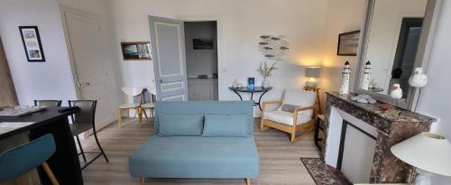 un salon avec une chaise bleue et une cheminée dans l'établissement Appartement Cosy hyper centre Villers, à Villers-sur-Mer