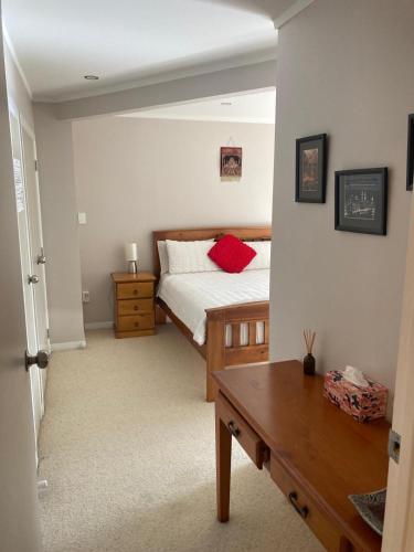 a bedroom with a bed with red pillows on it at Joe & Mary's Comfy homestay room in Auckland