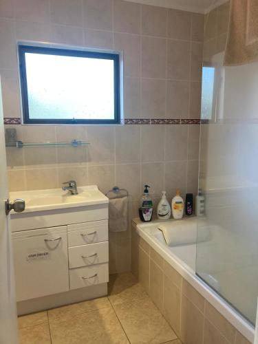 a bathroom with a tub and a sink and a shower at Joe & Mary's Comfy homestay room in Auckland