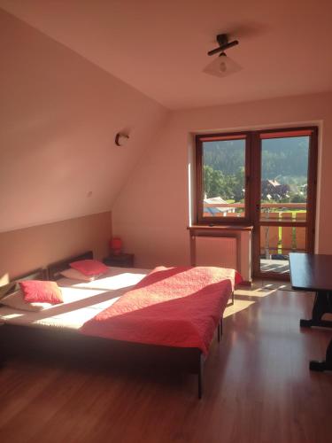 a bedroom with two beds and a large window at Środkowa 20 in Białka Tatrzanska