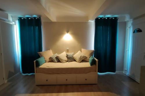 - une chambre avec un lit doté de rideaux bleus dans l'établissement Studio douillet à Grasse, à Grasse