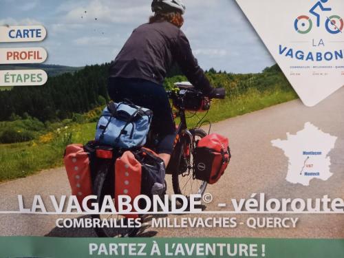 a man riding a bike down a road with bags at Les Papillons in Vrolle