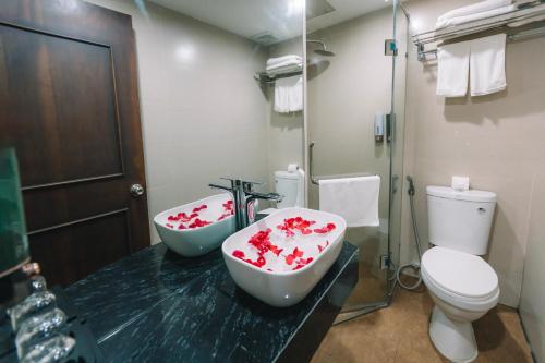 a bathroom with two sinks and a toilet at Ha Noi Lake View Hotel & Travel in Hanoi