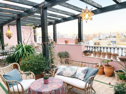 a patio with chairs and a table on a balcony at Ático la Estrella in Alcalá de Guadaira