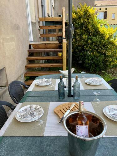 - une table avec des assiettes et des bouteilles de vin dans l'établissement casa arredata, à Corny-sur-Moselle