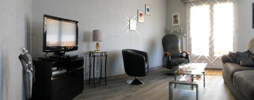 un salon avec un canapé et une télévision dans l'établissement maison 1 à 6 personnes avec garage et cour, à Kaltenhouse