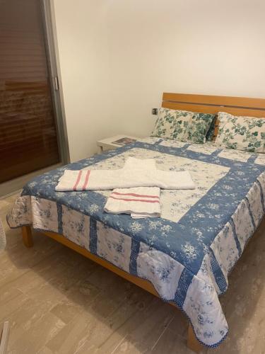 - un lit avec une couette bleue et blanche dans l'établissement NICE FLAT WITH GARDENS Limites cannes juste 10 MNS CROISETT, au Cannet