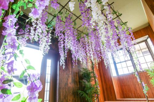 a bunch of purple and white flowers hanging from a ceiling at Urayasu Villa in Tokyo