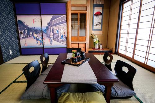 a dining room with a table and chairs with a person sitting at it at Urayasu Villa in Tokyo