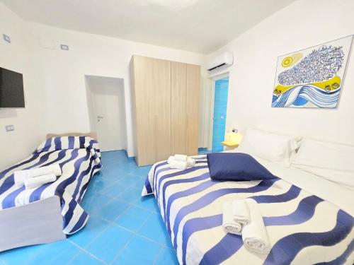 two beds in a room with blue at Chiaia Di Rose Rooms & Apartment in Ischia