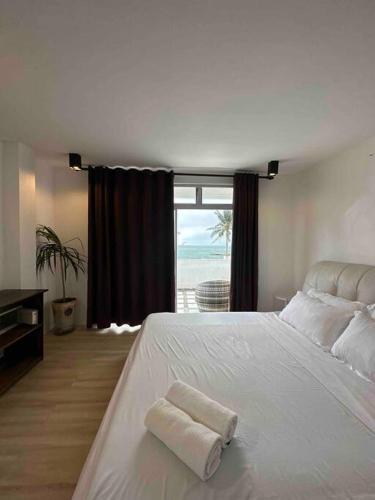 a bedroom with a white bed with a towel on it at Two Bedroom Beachfront Penthouse in Boracay