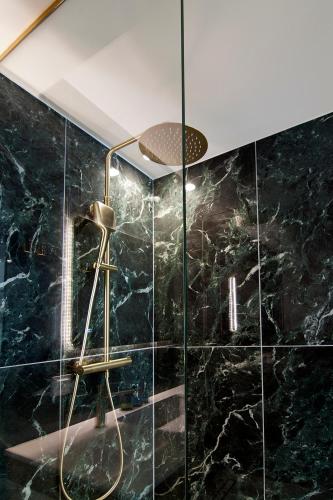 a bathroom with a shower with black marble at Solo Bianco Suites in Lefkada