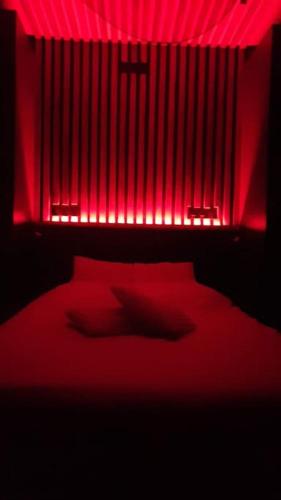 - une chambre rouge dotée d'un lit avec des lumières rouges dans l'établissement Studio quartier Boulingrin Reims, à Reims