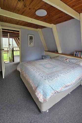 a bedroom with a bed with a wooden ceiling at Cherswood Farm in Balbarrup