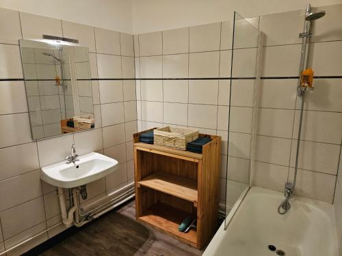 a bathroom with a sink and a toilet and a tub at Appartement Le Jardin Imaginaire in Champagnole