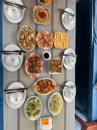une table avec de nombreuses assiettes de nourriture dessus dans l'établissement Like hostel, à Hai Phong