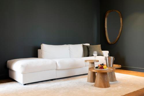 a living room with a white couch and a mirror at Hotel des Brasseurs in De Haan