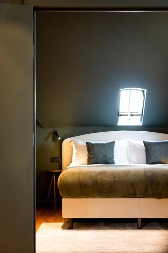 a bedroom with a large bed with a window at Hotel des Brasseurs in De Haan