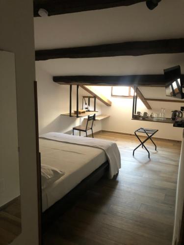 a bedroom with a bed and a table and chairs at La Sosta nel Borgo in Anguillara Sabazia