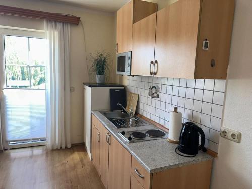 a small kitchen with a sink and a refrigerator at Seehaus Mamming - Hotel - Schlaffässer - Biergarten - Camping in Mamming