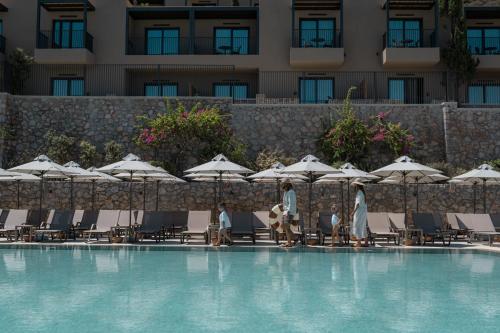 a group of chairs and umbrellas next to a swimming pool at Elios Hill in Hersonissos