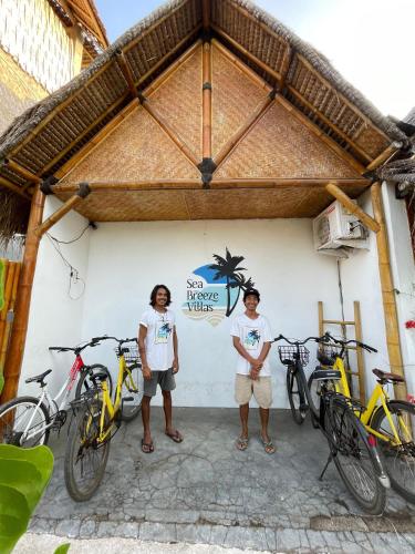 two people standing in front of a building with bikes at Sea Breeze Villas - Gili Air, Lombok in Gili Air