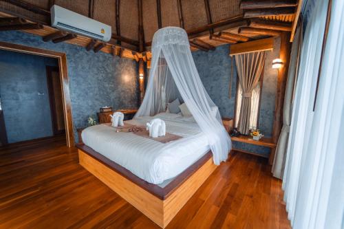 a bedroom with a bed with a mosquito net at View Point Resort in Koh Tao